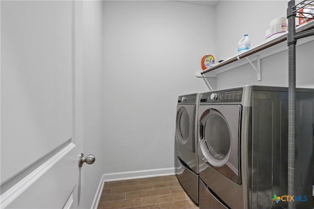 laundry area with dark wood-type flooring and washer and clothes dryer