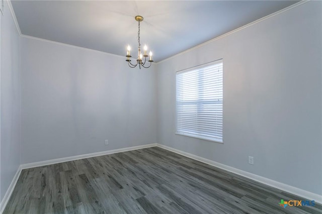 spare room featuring dark wood-type flooring, crown molding, and a notable chandelier