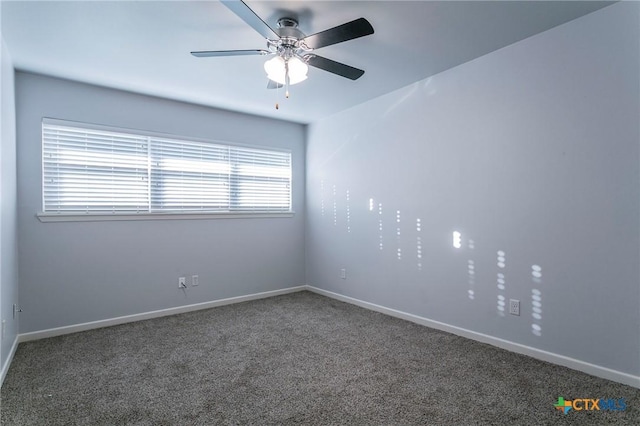 empty room featuring dark colored carpet and ceiling fan