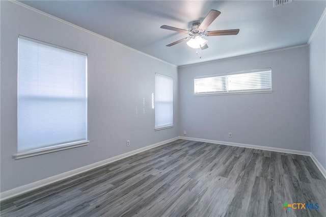 empty room featuring crown molding, dark wood-type flooring, and ceiling fan