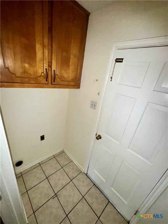 laundry room featuring light tile patterned flooring and cabinets