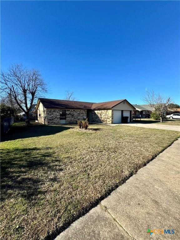 ranch-style home with a garage and a front yard