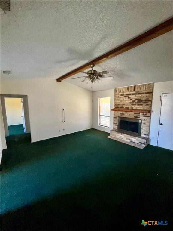 unfurnished living room with ceiling fan, a fireplace, a textured ceiling, beamed ceiling, and carpet floors