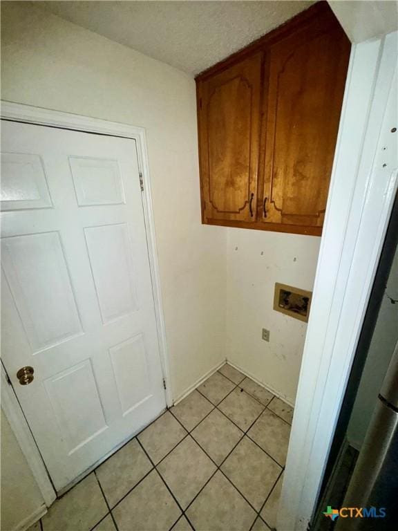 laundry room featuring cabinets, light tile patterned floors, and hookup for a washing machine