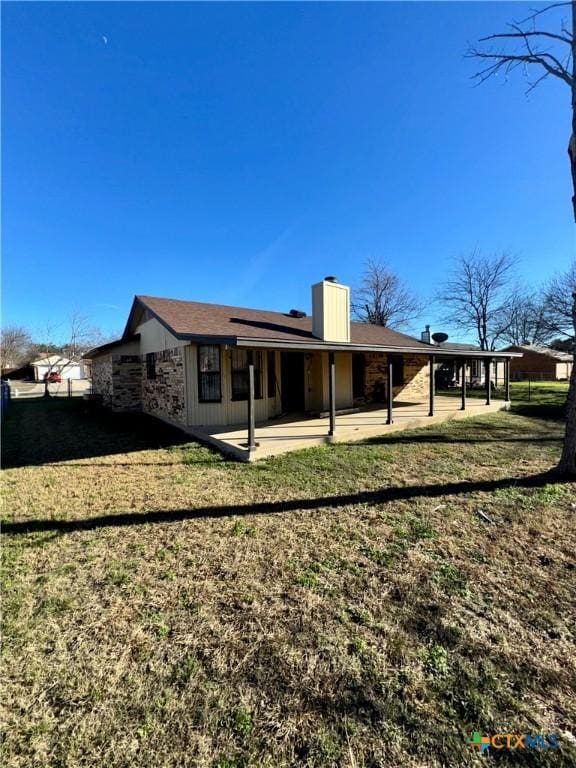 back of property with a patio area and a yard