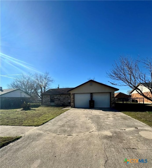 ranch-style house featuring a garage and a front lawn