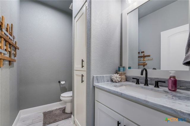 bathroom featuring hardwood / wood-style floors, vanity, and toilet