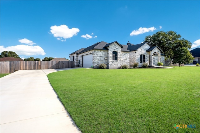 french country home featuring a garage and a front yard