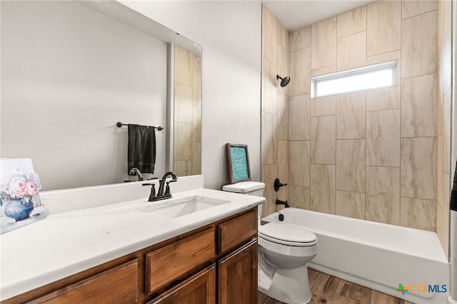 full bathroom featuring toilet, tiled shower / bath combo, vanity, and hardwood / wood-style floors