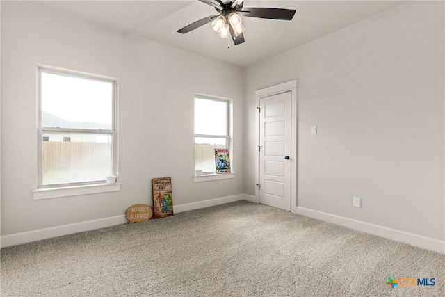 carpeted spare room with ceiling fan