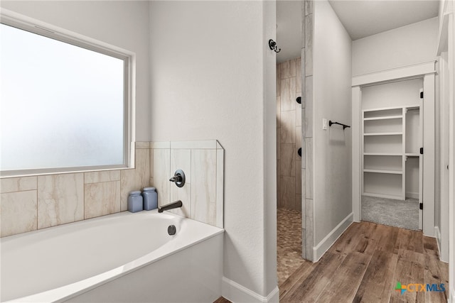 bathroom featuring hardwood / wood-style flooring and plus walk in shower