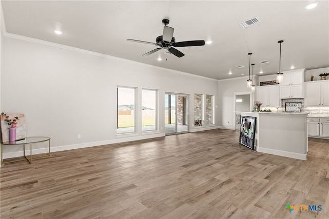 unfurnished living room with ceiling fan, light hardwood / wood-style flooring, and crown molding