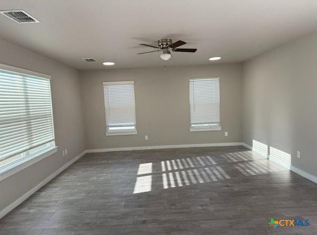 spare room featuring dark hardwood / wood-style flooring and ceiling fan