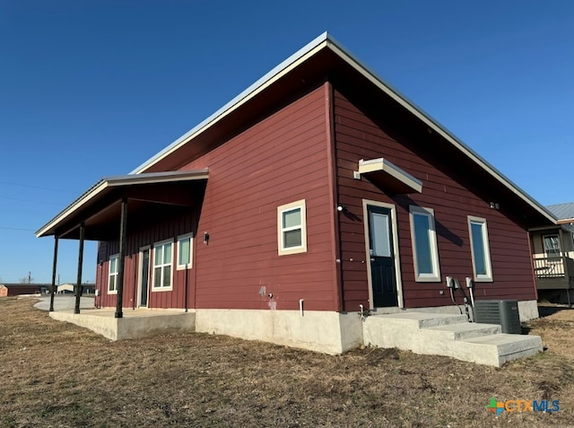 back of house featuring cooling unit and a lawn