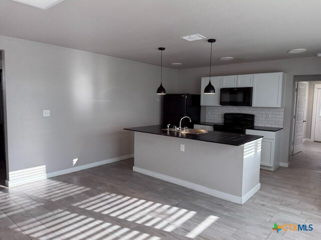 kitchen with sink, hanging light fixtures, black appliances, an island with sink, and white cabinets