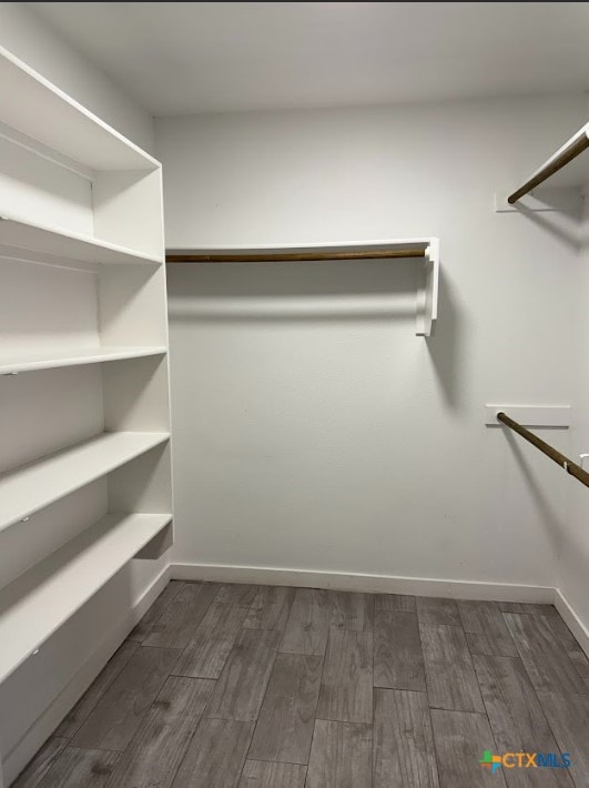 spacious closet with dark hardwood / wood-style floors