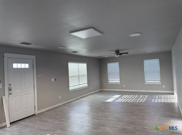 foyer with a textured ceiling, ceiling fan, and light wood-type flooring