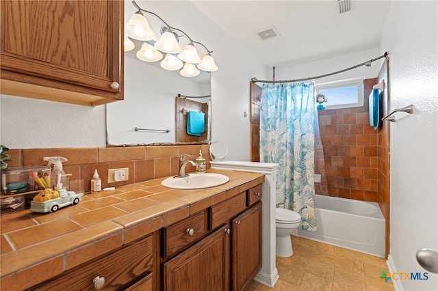 full bathroom with tasteful backsplash, shower / bath combo with shower curtain, vanity, tile patterned floors, and toilet