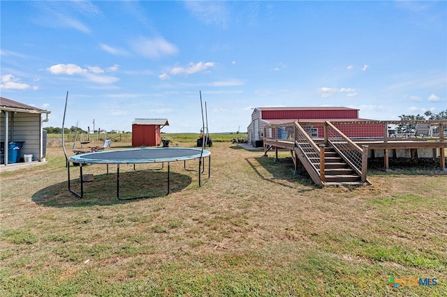 view of yard with a trampoline and a deck