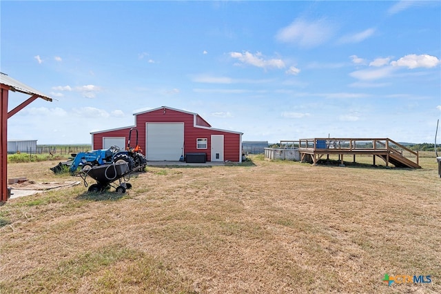 view of yard featuring an outbuilding, a garage, and a wooden deck