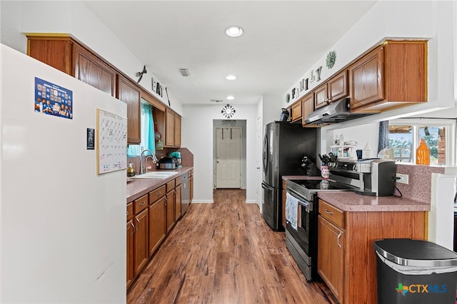 kitchen with extractor fan, stainless steel appliances, wood-type flooring, and sink