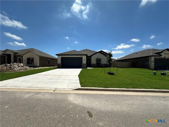 503 Magnolia Dr, Troy, TX 76579 - view of front of home featuring stone siding, concrete driveway, and a garage