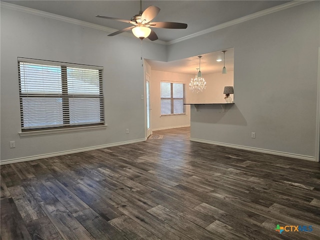 spare room featuring ornamental molding, ceiling fan with notable chandelier, and dark wood-type flooring