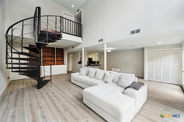3300 Yorktown St Unit 13, Houston, TX 77056 - living area featuring a towering ceiling, stairway, wood finished floors, and recessed lighting