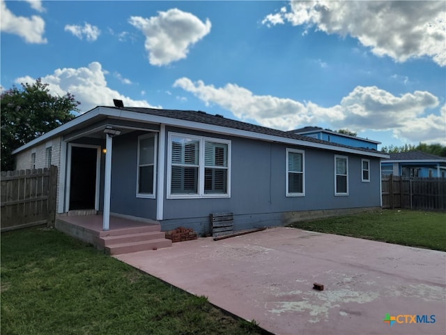 back of property with a patio and a yard