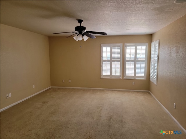 empty room featuring a textured ceiling, light carpet, and ceiling fan