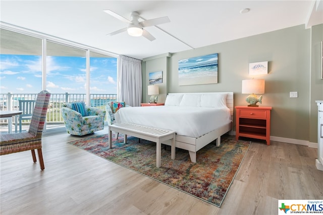 bedroom with expansive windows, ceiling fan, light wood-type flooring, and access to outside