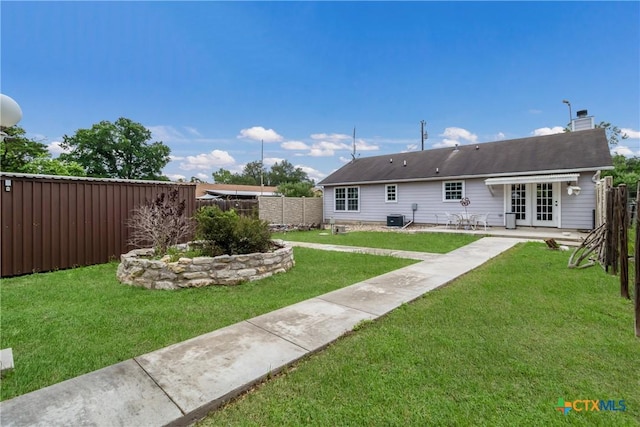 rear view of property with a patio, french doors, fence, central AC unit, and a yard