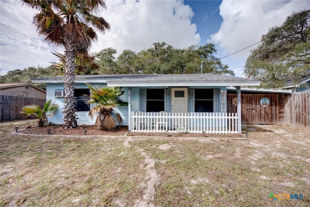 view of front of house with a porch, fence, and a front lawn