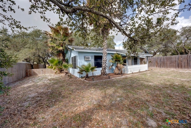 back of property with a lawn and a fenced backyard