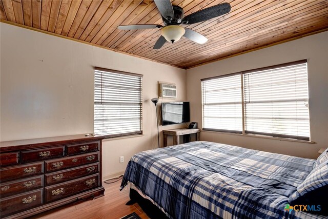 bedroom featuring a wall mounted air conditioner, light wood-type flooring, wooden ceiling, and ceiling fan