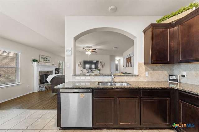 1401 Juneberry Park Dr, Temple, TX 76502 - kitchen featuring stainless steel dishwasher, a sink, a ceiling fan, a fireplace, and light stone countertops