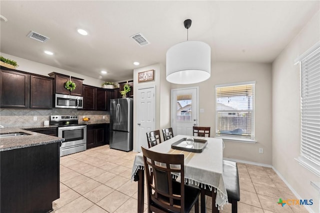 1401 Juneberry Park Dr, Temple, TX 76502 - kitchen featuring appliances with stainless steel finishes, tasteful backsplash, light tile patterned floors, dark brown cabinetry, and pendant lighting