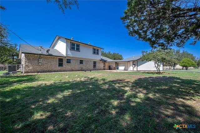 back of house with a lawn and a garage