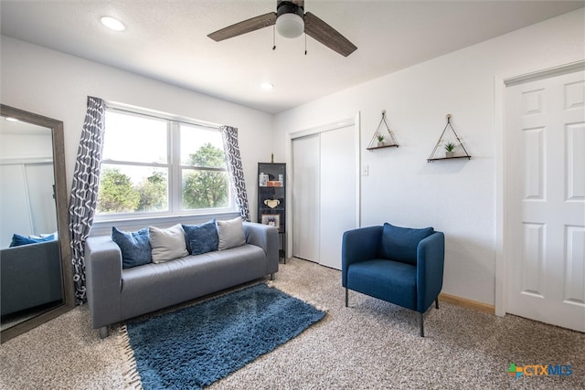 carpeted living room with ceiling fan