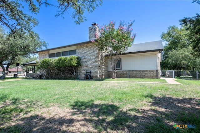 view of front of house featuring central air condition unit and a front yard