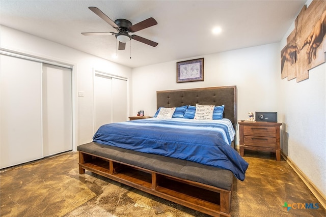 bedroom featuring multiple closets, ceiling fan, and dark colored carpet