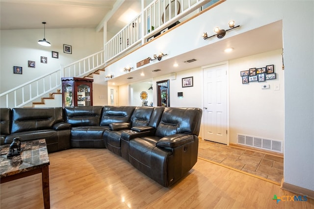 cinema with hardwood / wood-style floors and high vaulted ceiling