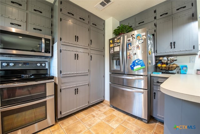 kitchen with stainless steel appliances and gray cabinetry