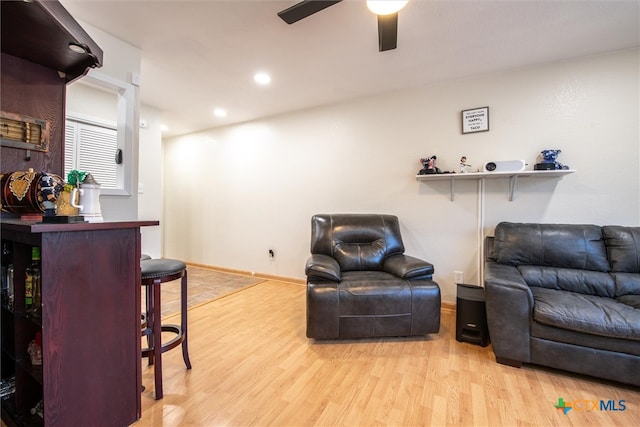 living room featuring ceiling fan and light hardwood / wood-style flooring