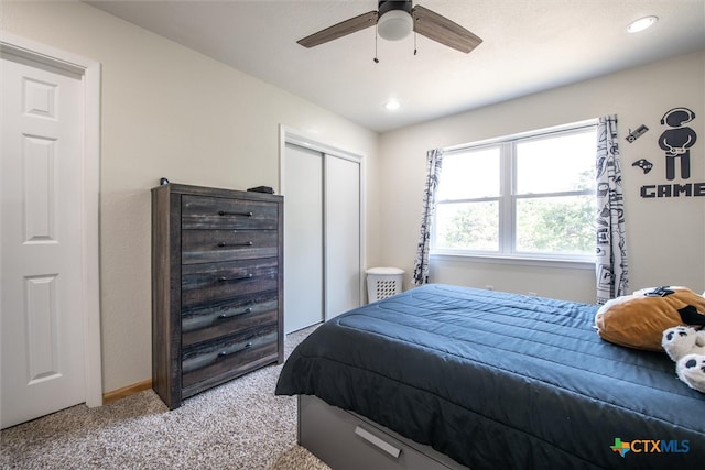 carpeted bedroom featuring ceiling fan and a closet