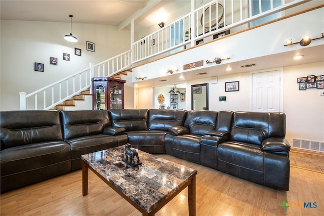 living room with hardwood / wood-style floors and high vaulted ceiling