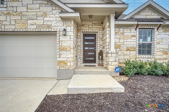 entrance to property featuring a garage and stone siding