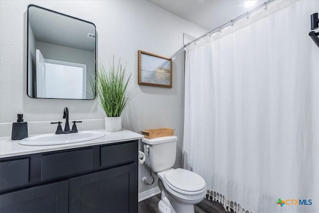 full bath with curtained shower, toilet, wood finished floors, vanity, and baseboards