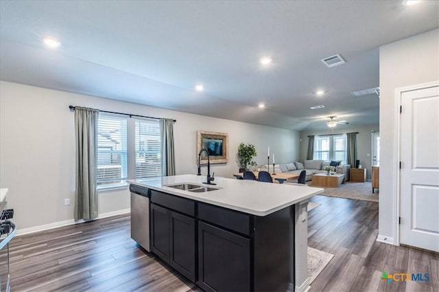 kitchen featuring light countertops, visible vents, stainless steel dishwasher, dark wood-type flooring, and a sink