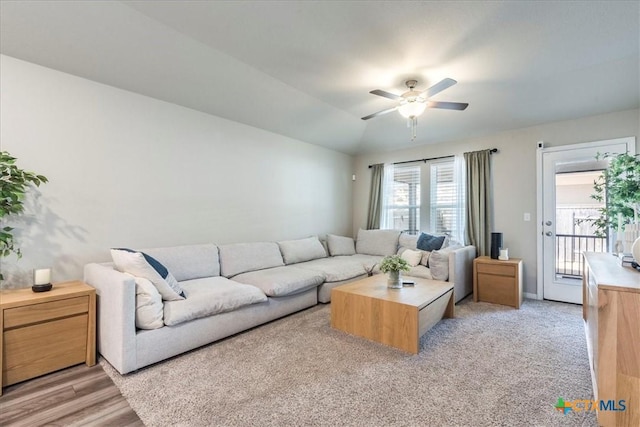 living room featuring lofted ceiling, ceiling fan, and baseboards